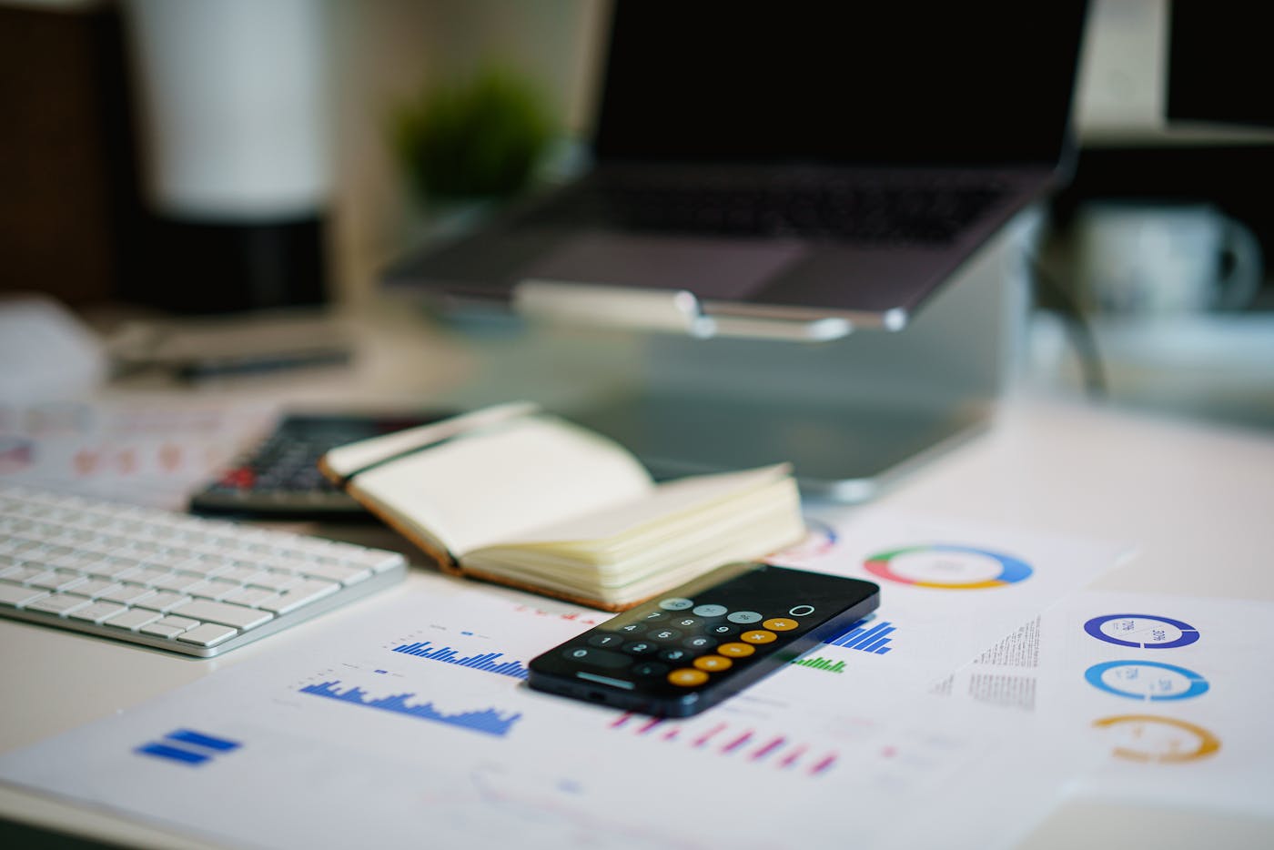 Financial charts, a calculator, and a laptop arranged for budget planning.